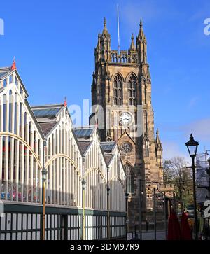 Die Dachlinie der viktorianischen Stockport Market Hall und der Uhrenturm der St. Mary’s Church (Stockport Parish Church) in der hellen Wintersonne, Marktplatz Stockfoto