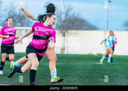 Zwei Fußballspielerinnen in Aktion, eine in Rosa und Schwarz, eine in Hellblau Stockfoto