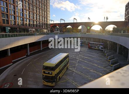Sonnenuntergang Winterblick über den Stockport Interchange Busbahnhof mit abfahrendem Doppeldeckerbus und Bögen des Stockport Eisenbahnviadukts im Hintergrund Stockfoto