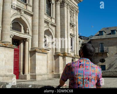 Rückansicht eines männlichen Touristen in einem bunten Hemd mit Blick auf die Kathedrale von Lugo: Reise- und Tourismuskonzept, Spanien Stockfoto