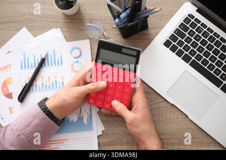 Männliche Hände, die Berechnungen im Büro machen. Nahaufnahme Stockfoto