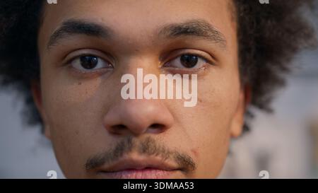Extreme Nahaufnahme Porträt Afroamerikaner Mann blickt hinunter Augen geschlossener Mann ethnischer junger Erwachsener ruhiges Zuhause drinnen gesunde Haut Gesichtsausdruck Stockfoto