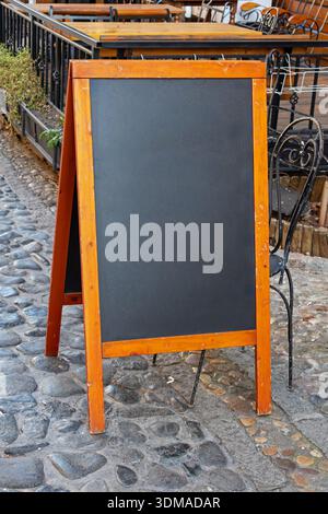 Leere Schwarztafel mit Holzrahmen auf der Straße draußen Stockfoto