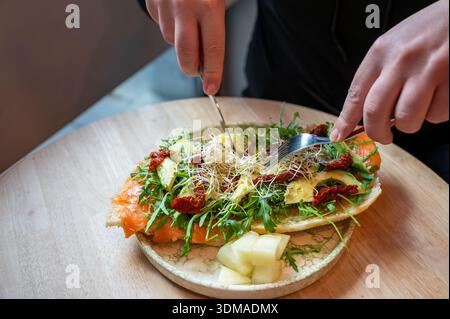 Elegante Bruschetta mit Lachs, cremiger Avocado und gemischtem Gemüse. Stockfoto