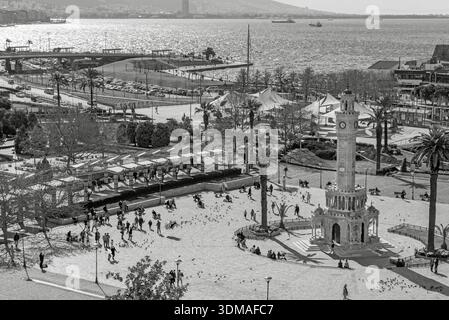 IZMIR, TÜRKEI - 17. März 2021: Blick aus einem hohen Winkel auf den historischen Osmanischen Uhrturm und die Menschen auf dem Konak-Platz. Schwarzweiß-Straßenfotografie. Stockfoto