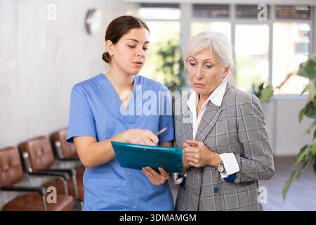 Aufmerksame Ärztin verschreibt Tests an Patienten der Klinik, um den Gesundheitszustand zu überprüfen Stockfoto