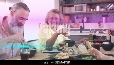 Wir teilen uns vier Erwachsene, eine Frau mit blassgelbem Hemd, isst Sushi mit Essstäbchen am Küchentisch Stockfoto