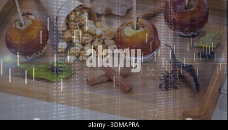 Drei Karamelläpfel auf Holzbrett mit Popcorn, Zimt und Finanzüberzug Stockfoto