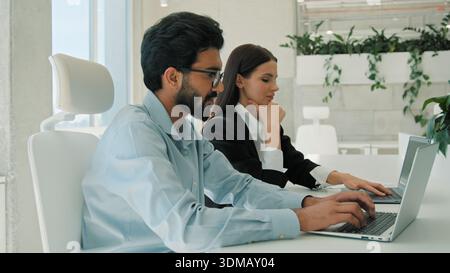 Multiethnisches Geschäftsteam diskutiert Ideen Laptop in Büroleiter Coaching von Kollegen kaukasisch-arabische Geschäftsmänner Geschäftsfrauen Brainstorming Stockfoto