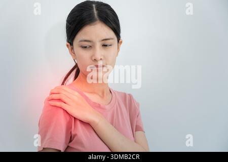 Frau, die an der Schulter und während und leiden unter unerträglichen Schmerzen Gesundheit und Problemen, chronischen Schulterschmerzen, Schulterschmerzen beim Büro-Syndrom, scol Stockfoto