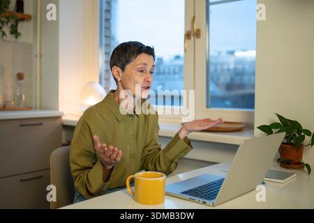 Selbstbewusste Geschäftsfrau spricht online per Videoanruf auf einem Laptop und diskutiert mit Kollegen über die Arbeit Stockfoto
