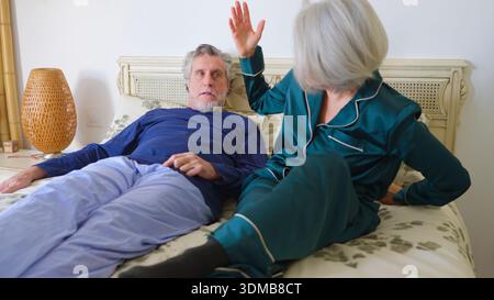Seniorenpaar diskutieren im Bett während des Konflikts Stockfoto