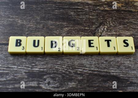Scrabble-Kacheln beschreiben Budgets on Wood und stellen die Finanzplanung, Ressourcenzuweisung und strategische Verwaltung in wirtschaftlicher oder organisatorischer Hinsicht dar Stockfoto