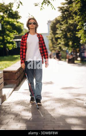 Vorderansicht, zu Fuß. Der blinde Junge ist draußen in der Stadt. Stockfoto