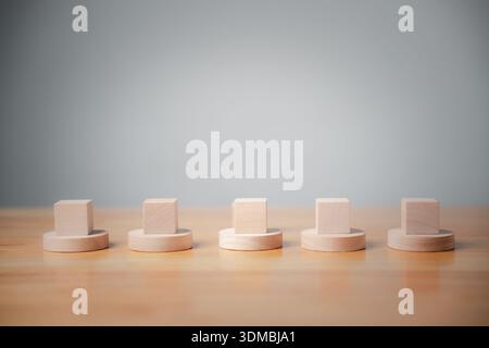 Dieses minimalistische Konzept, die Geschäftsidee, zeigt leere Holzblöcke in einer Reihe, die das Personal oder die Strategie für eine erfolgreiche Stiftung in einem gr Stockfoto