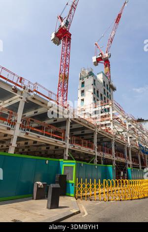 Große Baustelle mit roten Turmkränen und Stahlrahmen. London, Vereinigtes Königreich, 11. Mai 2024 Stockfoto