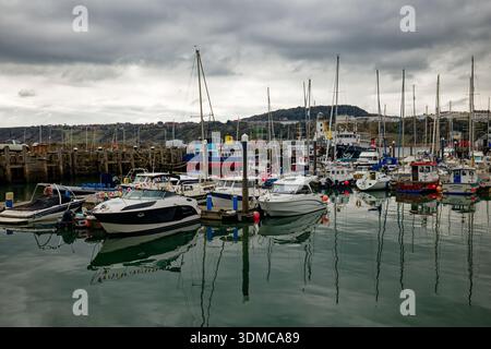 Ein Wald von Yachtmasten von Booten, die im Hafen mit dem Resort Scarborough an der Küste im Hintergrund, North Yorkshire, England, vertäut sind. Stockfoto