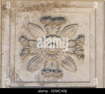 Altes Basrelief aus Stein mit Blumenrosette, Basilika von Aquileia (Basilica di Aquileia), Italien. Romanische architektonische Dekoration. Stockfoto