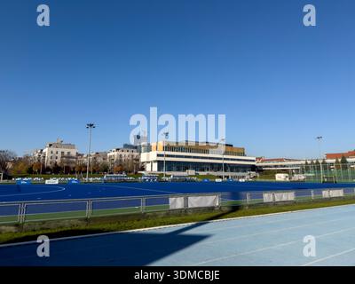 Posen, Polen - 18. November 2025: Pulsierendes blaues Feld-Hockeyfeld und eine Laufbahn mit PZU Sport-Branding in einem modernen Sportkomplex Stockfoto