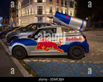 Posen, Polen - 18. November 2025: Red Bull Mini Cooper Fahrzeug mit riesiger Energiekanne, nachts auf der städtischen Straße geparkt, um eine effektive Markenwerbung zu ermöglichen Stockfoto