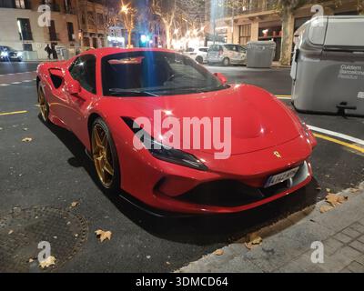 Detail eines spektakulären roten Ferrari F8 Supersportwagens, der nachts auf den Straßen von Barcelona vor einem Luxushotel parkt Stockfoto
