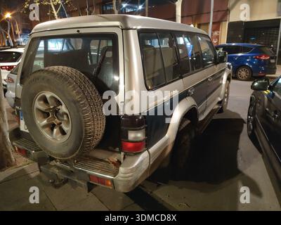 Hinter einem alten japanischen SUV der zweiten Generation Mitsubishi Pajero Montero V20, der nachts auf der Straße der Stadt geparkt wurde Stockfoto