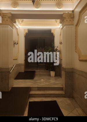 Detail der klassischen Lobby eines Wohngebäudes in der Muntaner Straße in Barcelona, Beleuchtung ​​warm, Marmortreppen und im Hintergrund die alte CA Stockfoto