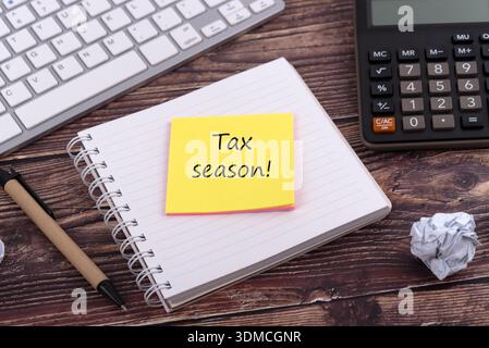 Hochwinkelansicht von Notizblock und Klebenotiz mit Text Tax Season Stockfoto