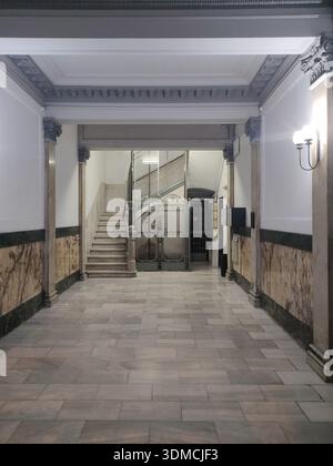 Detail der klassischen Lobby eines Wohngebäudes in der Muntaner Straße in Barcelona, ​​marble Etage und im Hintergrund ein alter Käfigaufzug Stockfoto