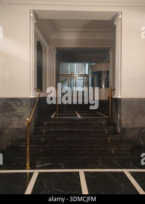 Detail einer alten Lobby eines Wohngebäudes im oberen Bereich von ​​Barcelona, schwarze Marmordekoration in ​​two-Ton auf dem Boden und weiß Stockfoto