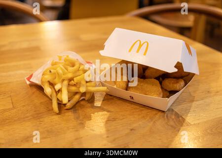 Posen, Polen - 19. November 2025: McDonald's Chicken Nuggets und goldene Pommes Frites in Markenverpackung, die beliebte Fast Food und schnelle ca. Stockfoto