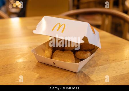 Poznan, Polen – 19. November 2025: McDonald's Famous Chicken McNuggets füllen eine offene weiße Box, bereit für den Verzehr auf einem Holztisch in einer zwanglosen Atmosphäre Stockfoto