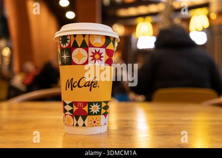 Posen, Polen - 19. November 2025: Nahaufnahme einer McCafe Kaffeetasse mit farbenfrohen Mustern, die einen erfrischenden Drink-Moment in einem McDonald's Res bietet Stockfoto