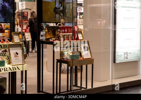 Posen, Polen – 19. November 2025: Ein mehrstufiges goldenes Display zeigt Rabanne Luxusparfüms und Schönheitsprodukte, die Kunden in ein geschäftiges Geschäft ziehen Stockfoto