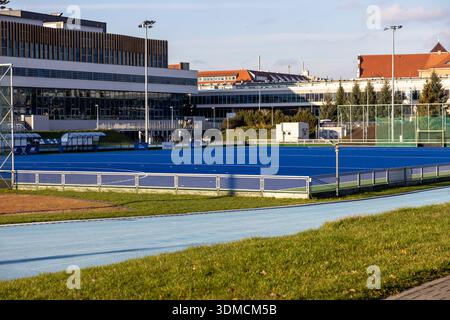 Posen, Polen - 19. November 2025: Leeres blaues Feld-Hockeyfeld und hellblaue Laufbahn, die einen modernen Sportkomplex für den sportlichen traini darstellt Stockfoto