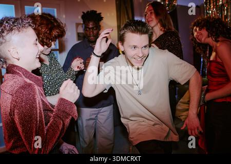 Gruppe junger Erwachsener, die bei Indoor Party Meeting tanzen und gesellig sind Stockfoto