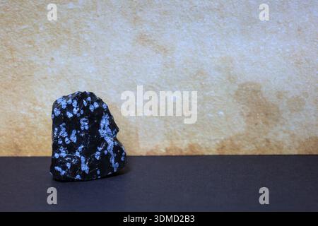 Ein obsidianisches Snowflake-Mineral mit typischen weißen Cristobalit-Flecken, geeignet für Grafik in Wissenschaft und Bildung. Stockfoto