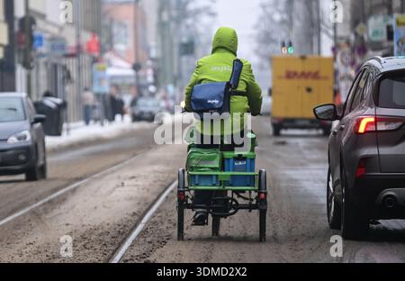 Berlin, Deutschland. Februar 2026. Ein Fahrer des Postdienstleisters PIN AG fährt mit dem Fahrrad auf einer mit Schlamm bedeckten Straße. Quelle: Britta Pedersen/dpa/Alamy Live News Stockfoto