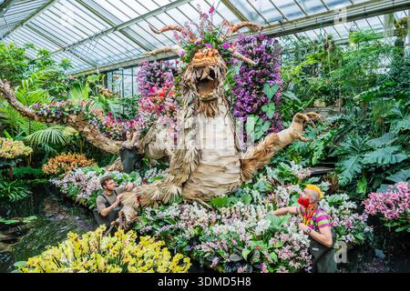 London, Großbritannien. Februar 2026. Kew Gärtner (darunter Henck Röling (Künstler, Florist und Kew-Botschafter) und Soline Dequiret), die den letzten Schliff auf die zentrale Ausstellung im Gewächshausteich mit einem Drachen aus Lotussamen (und mit Schuppen aus Abfallmaterial aus den Gärten) setzen - Kew Gardens 30. Jährliches Orchideenfestival im Princess of Wales Conservatory, Kew Gardens. Guy Bell/Alamy Live News Stockfoto