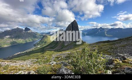 Der legendäre Segla-Gipfel erhebt sich über der Fjordlandschaft auf der Insel Senja im Norden Norwegens. Panoramablick auf den arktischen Sommer mit dramatischen Wolken. Stockfoto