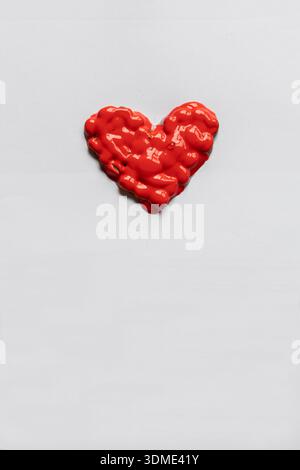 Ein rot gemaltes, selbstgemachtes Herz in Form eines Herzens als symbolisches Foto Stockfoto