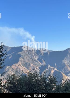 Rauch steigt über dem Bergkamm aus dem Lauffeuer in Kalifornien, USA. Stockfoto