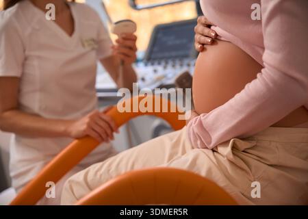 Schwangere Frau in der Arztpraxis zur Vorbereitung der Ultraschalluntersuchung Stockfoto