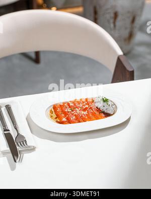 Lachsscheiben mit cremiger Sauce und Kräutern Stockfoto