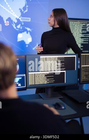 Team, das Cybersicherheitsanalysen in einem High-Tech-Kontrollraum durchführt Stockfoto