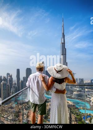 Rückansicht eines eleganten Touristenpaares mit Panoramablick auf die Skyline von Downtown Dubai, VAE, von ihrem Balkon Stockfoto