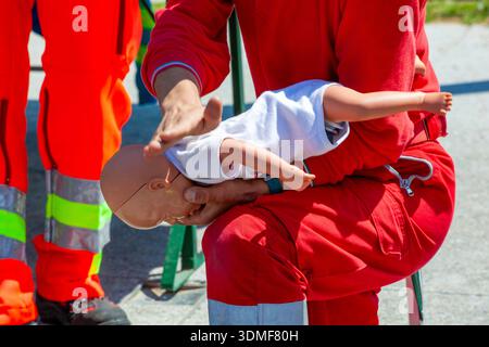 Ersthelfer, der erste-Hilfe-Training an Säuglingspuppe durchführt Stockfoto