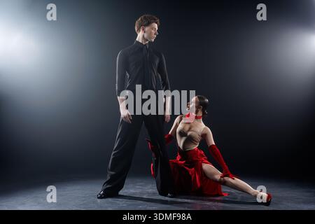 Tanzpaare im Ballsaal, die eine ausdrucksstarke Pose in einem professionellen Studio spielen. Ideal für Werbebanner, Websites und visuelle Inhalte Stockfoto