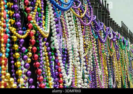 Bunte mardi Gras Perlen hängen an einem Zaun Stockfoto