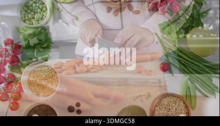 Hackende Frau in rosa Pullover, die Karotten auf Schneidebrett an der Küchentheke mit Kochmesser schneidet Stockfoto